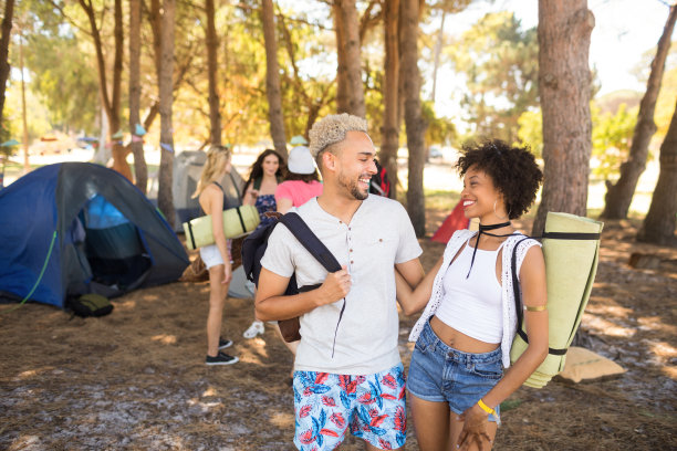 一对微笑的情侣站在球场上，身后是朋友图片下载