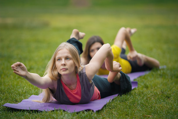 两名年轻女子在公园里进行柔韧性训练图片下载