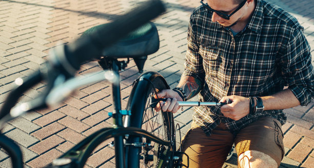 年轻男子自行车泵轮自行车，准备旅行，维修运输概念图片下载