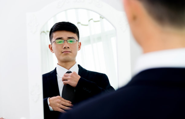 年轻的亚洲商人正在调整领带图片下载