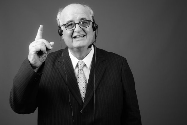 工作室拍摄的年长商人戴着眼镜在灰色背景的黑白图片下载