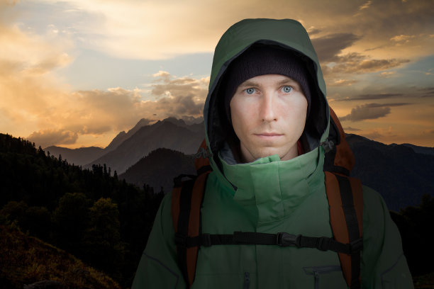 一个背着背包的男人在夕阳的背景下。徒步旅行图片下载