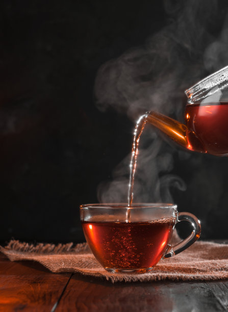 泡茶过程，茶道，一杯新泡的红茶，光线温暖柔和，背景较暗。图片下载