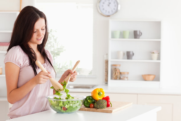 红头发的女人正在准备沙拉图片下载