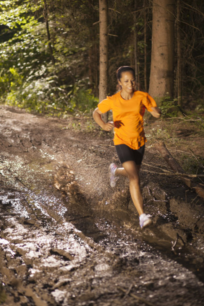 女跑步者穿过泥地。图片下载