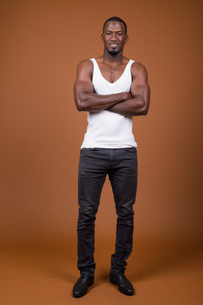 工作室拍摄的肌肉英俊的非洲男子穿着背心，以彩色背景图片下载