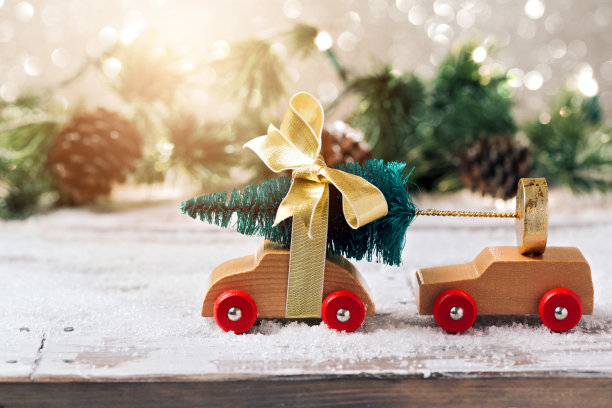 圣诞树上的玩具汽车在节日的背景。圣诞节庆祝概念图片下载