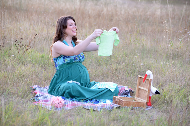 快乐的孕妇在户外为她的宝宝准备东西图片下载