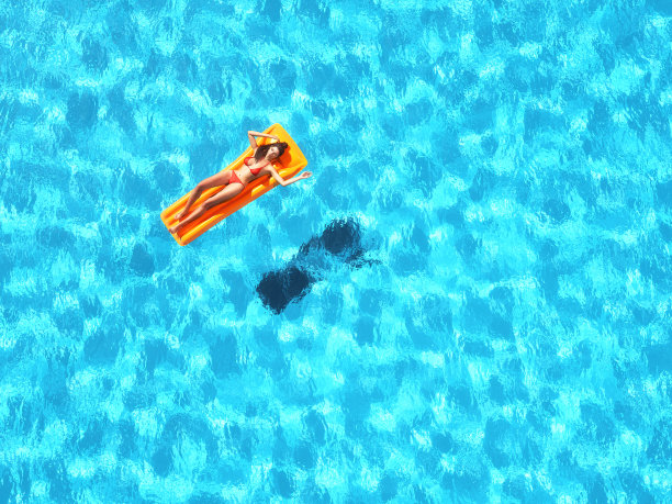 年轻女孩坐在沙滩床垫上图片下载