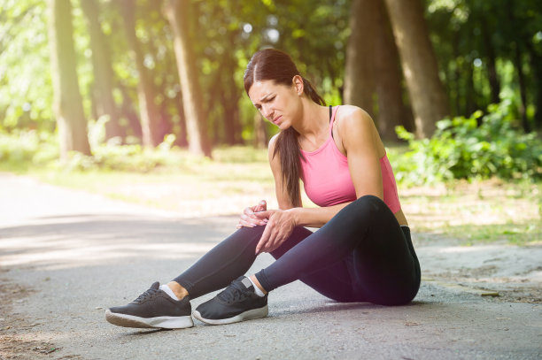 一个女人在公园里膝盖疼痛图片下载