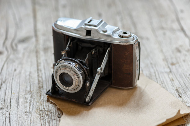 在前景的木头桌子上的旧照相机图片下载