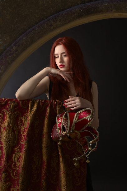 带着狂欢节面具的红发美女。图片下载