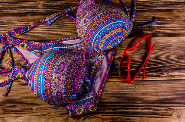 木制背景上的泳衣和太阳镜。暑假的概念。俯视图图片下载