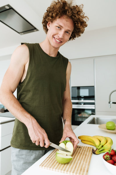 快乐的男人站在厨房做饭图片下载