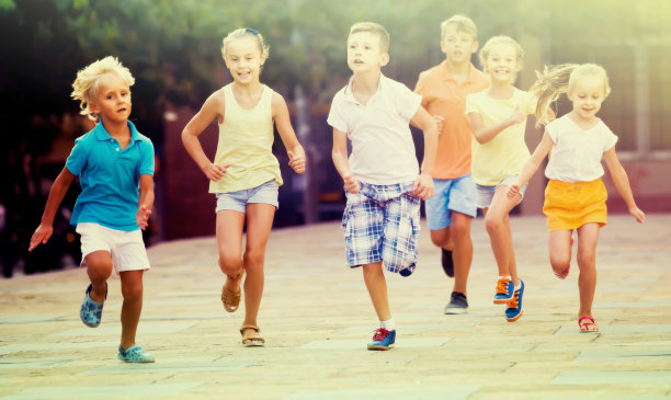 夏天的一天，孩子们在街上一起玩耍和奔跑图片下载