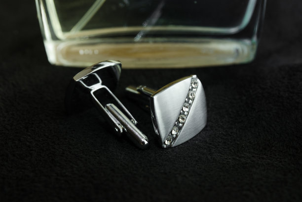 银色的袖扣躺在黑布上图片下载