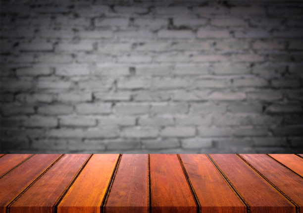 选择聚焦空棕色木桌和墙壁纹理或旧黑色砖墙模糊背景图像。为您的蒙太奇或产品展示图片下载
