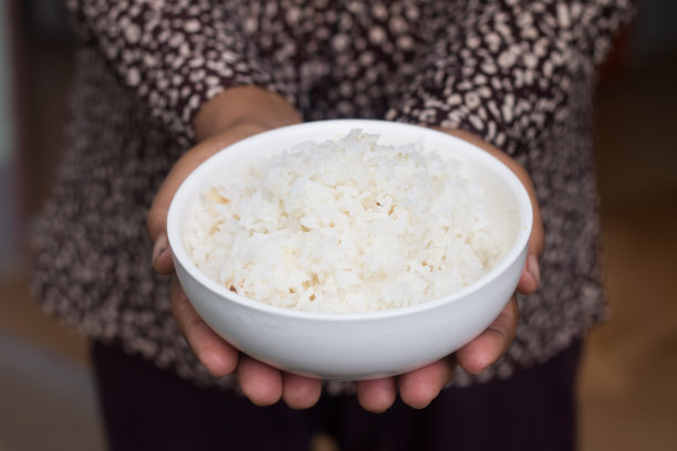 女人的手捧着一碗米饭图片下载