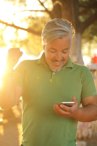 在户外使用手机的男人。图片下载