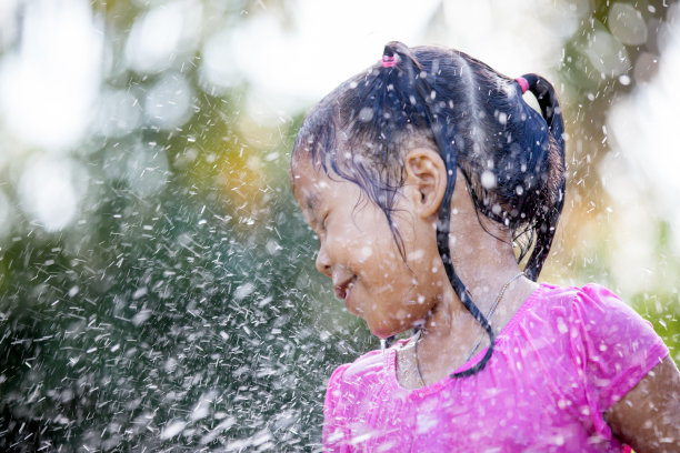 可爱的亚洲儿童女孩有乐趣洗澡和玩水溅在外面图片下载