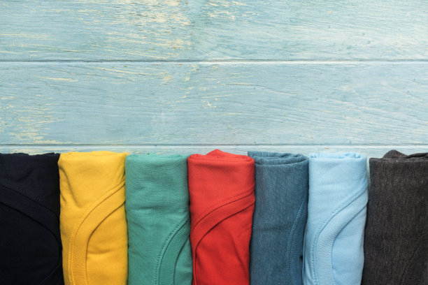 近卷的彩色衣服在桌子的背景图片下载