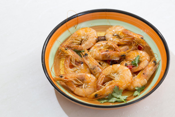 美味的海鲜虾用红辣椒、香菜和橄榄油制成，并盛在五颜六色的盘子里。图片下载