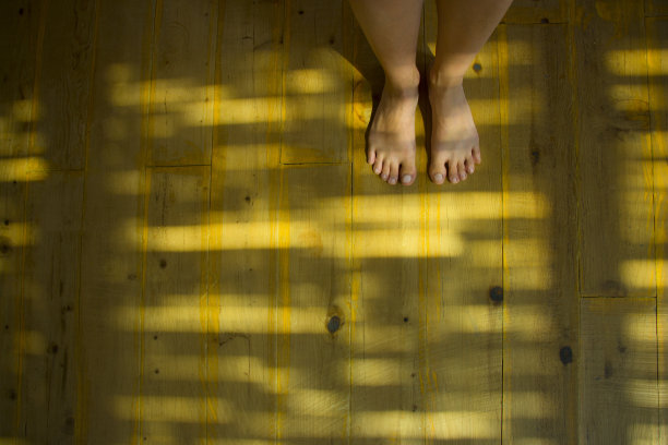赤脚站立的人在天然木地板上图片下载