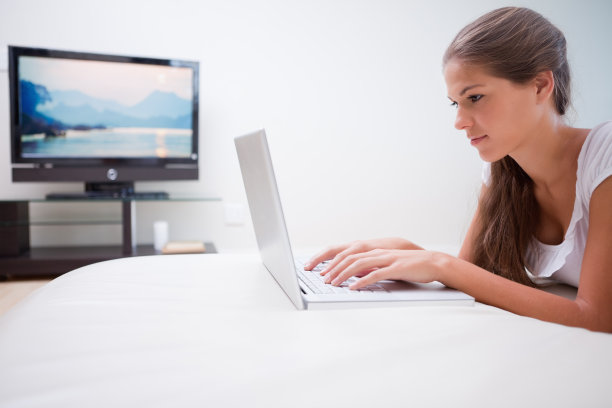 一个女人在用笔记本电脑看电视图片下载