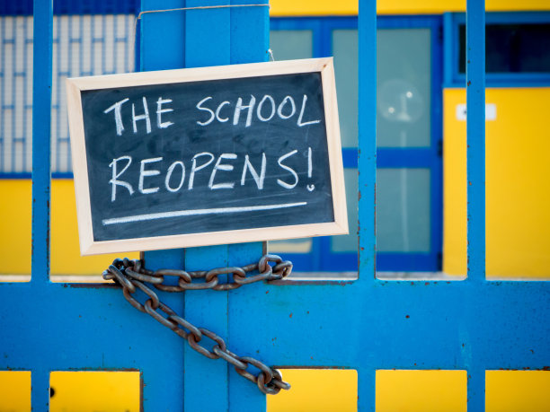 一所校门关闭了，校门上挂着一块黑板图片下载