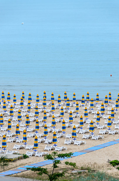 保加利亚阿尔贝纳的黑海海岸，金色沙滩，蓝色淡水，靠近海滩酒店的日光浴床和遮阳伞图片下载