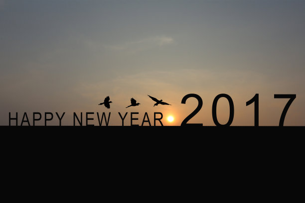 房屋顶上的2017数字剪影与暮光中的日出，新年和圣诞节概念素材图片