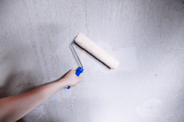 特写的人的手使用油漆滚轮工作图片下载