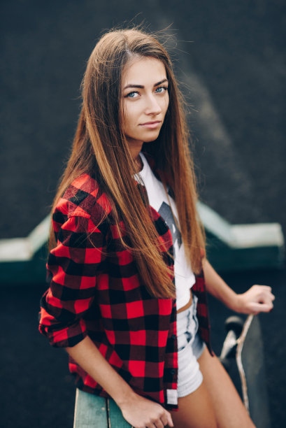 一个美丽可爱的年轻女孩的近距离肖像在红色的衬衫，白色的t恤和短裤图片下载