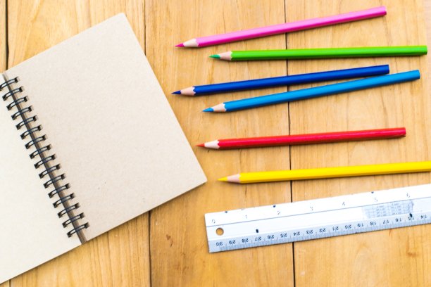 以木板为背景的铅笔记事本。使用壁纸或背景教育，商业照片。注意产品的纸张和概念或复制空间的书。图片下载