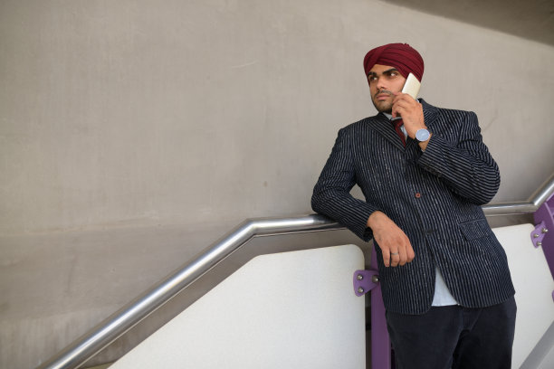 年轻英俊的印度锡克教商人戴着头巾在BTS空中火车站在泰国曼谷的肖像图片下载