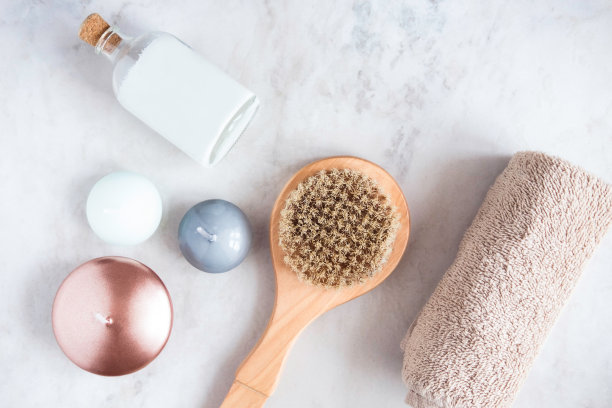 水疗美容产品从上面的白色大理石桌子。椰子油，刷子，蜡烛，毛巾。美容博主，按摩沙龙概念。素材图片