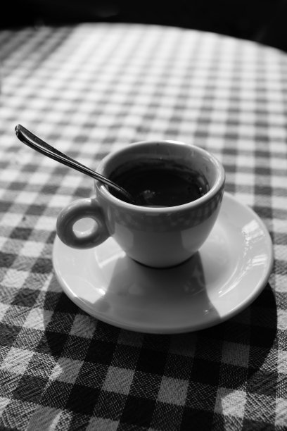 笼型桌布上孤独的咖啡杯。黑色和白色。图片下载