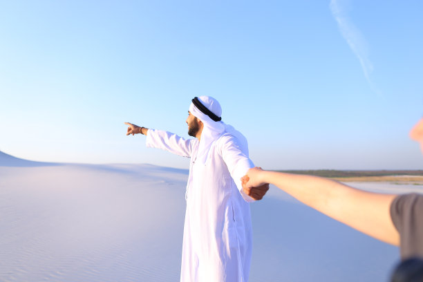 年轻的阿拉伯导游牵着女孩的手进行交谈图片下载