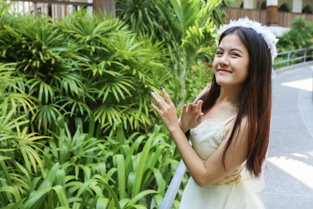 亚洲妇女与白色皇冠有很少的微笑与双手交叉图片下载