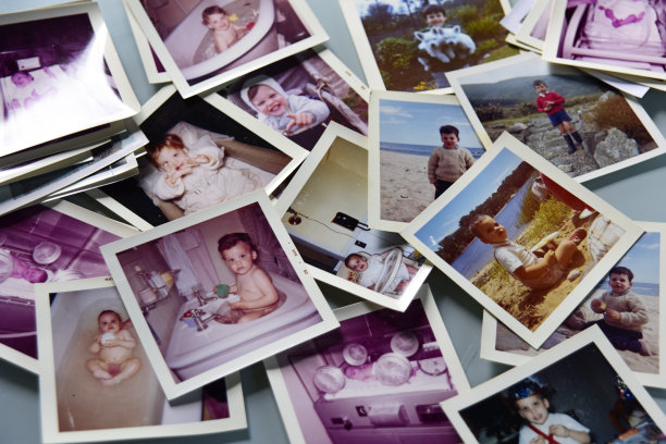 白色桌子上摊开了孩子的照片(同一个)。图片下载