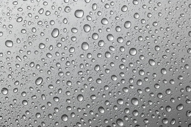 水滴落在银色的背景上。水滴在金属银色的背景上图片下载