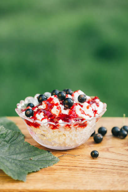 白软干酪，浆果果酱，新鲜黑加仑，一杯牛奶和一片新鲜烤面包在一个轻木制的背景。食物照片的概念。散景背景上的静物。美术风格图片下载