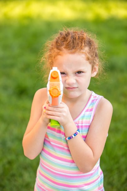 小女孩用水枪指着镜头图片下载