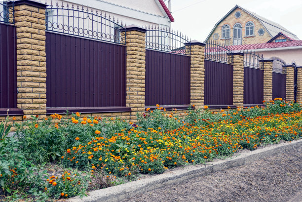 灰色的棕色栅栏和花坛旁边的门图片下载