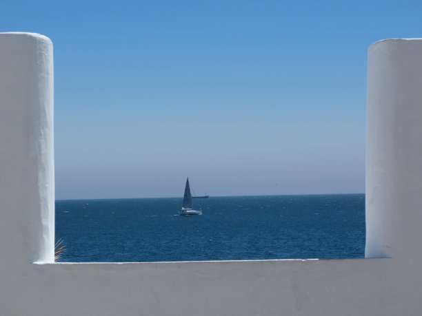 大海和小船后面的白墙，卡斯凯斯，葡萄牙图片下载