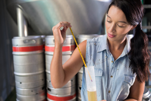 工人在工厂的试管里检验啤酒图片下载