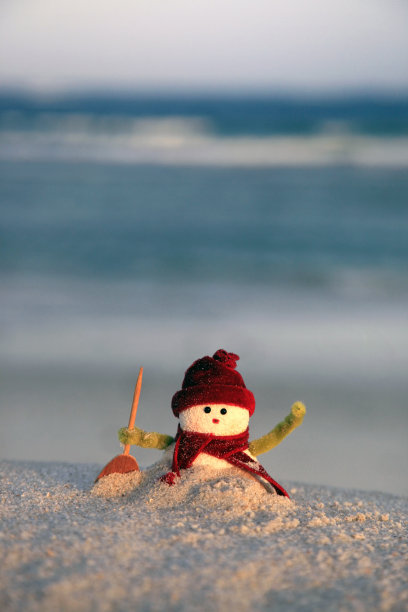 海滩背景上的雪人玩具图片下载