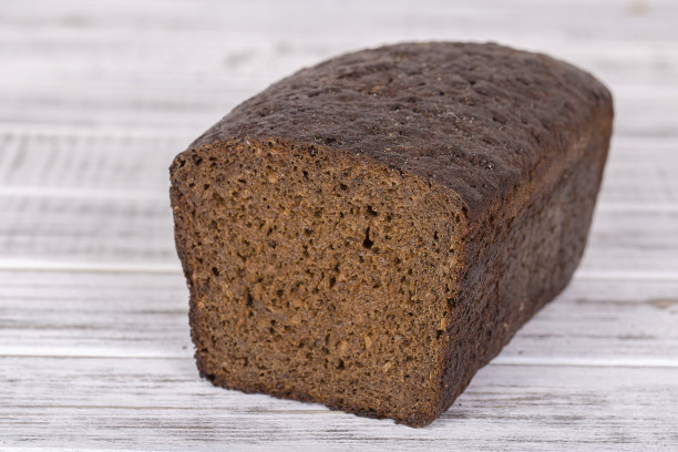 白木背景上的黑麦面包图片下载