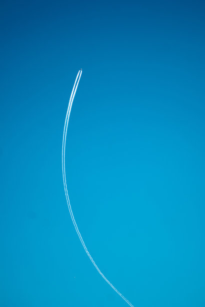 蓝天下飞机的剪影。后面有一缕烟图片下载