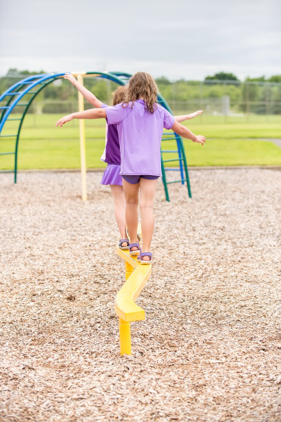 在公园户外操场上走平衡木的女孩图片下载